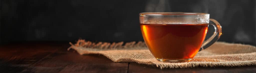 Are Disinfection Byproducts (DBPs) in your cup of tea?? - A Cup of freshly brewed black tea,escaping steam,warm soft light, darker background.