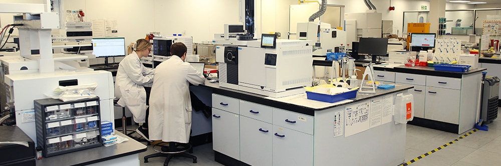 How a SATRA Lab Used LPGC to Cut Helium Use by 89% and Run Times by 50% - two chemists working in a lab