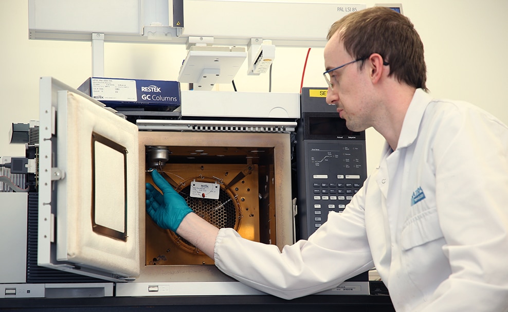 How a SATRA Lab Used LPGC to Cut Helium Use by 89% and Run Times by 50% - chemist installing an LPGC column in a GC